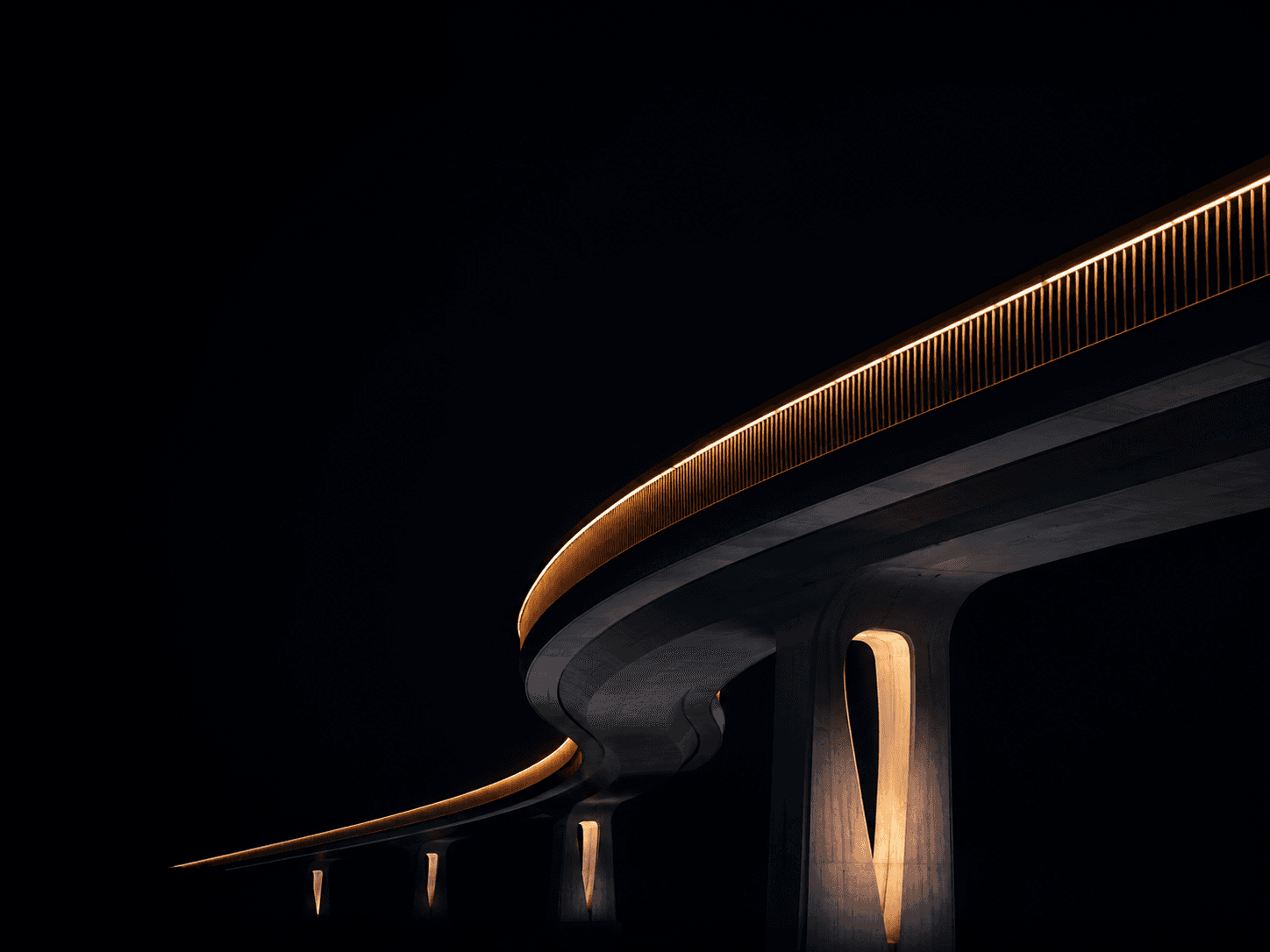 A curved structure lit by warm lights at night