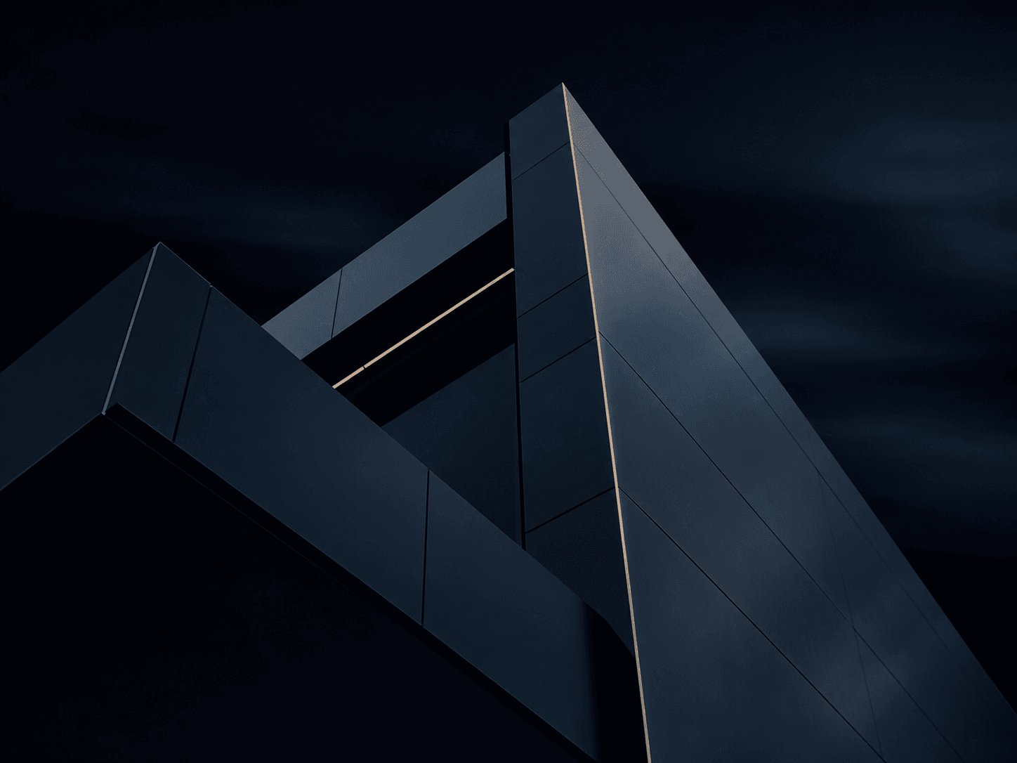 A dark modern building facade seen from below